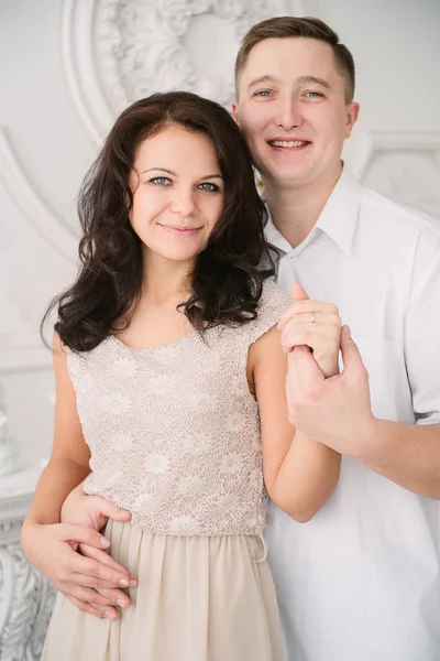 Jovem alegre casal europeu no amor abraçando e beijando em estúdio decorado, cores pastel luz, namoro . — Fotografia de Stock