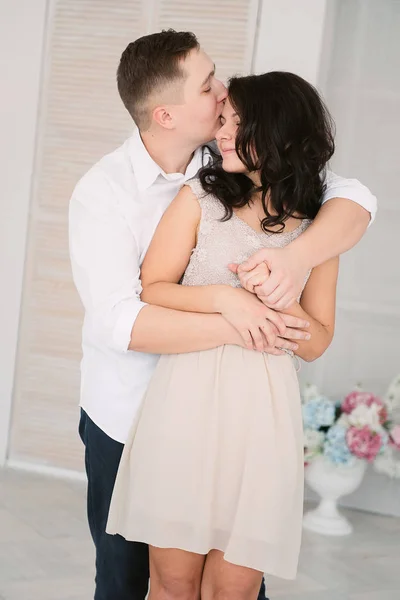 Jovem alegre casal europeu no amor abraçando e beijando em estúdio decorado, cores pastel luz, namoro . — Fotografia de Stock