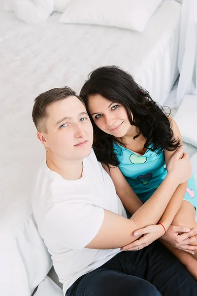 Jonge vrolijke Europese verliefde paar omarmen en kussen in ingerichte studio, lichte pastel kleuren, dating. — Stockfoto