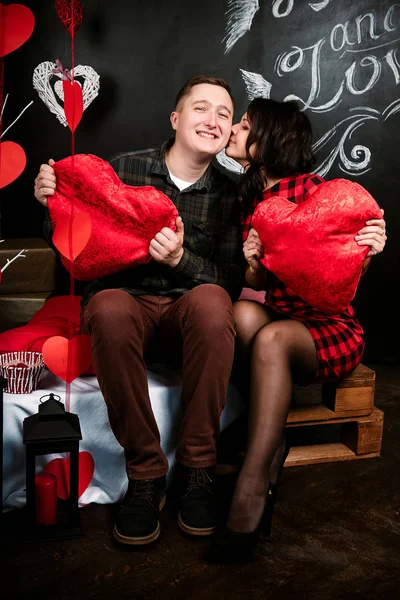 Веселий європейських молодят в любові, обіймаючи і поцілунки, в прикрашені серця студії на день Святого Валентина, знайомства. — стокове фото