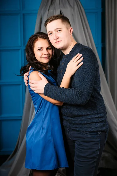 Mladý veselá Evropský pár v lásce objímat a líbat, v zdobené srdce studio na Valentýna, Seznamka. — Stock fotografie
