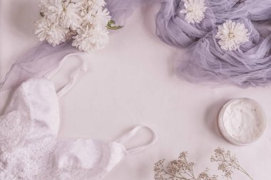 Düz moda blog ve sosyal medya için yatıyordu. Kadının glamour beyaz ve bej beyaz bir arka plan üzerinde güzellik aksesuarları. İç çamaşırı, mücevher, parfüm, krem, sabun, külot, uyku maskesi, sarmal saç bağları. C