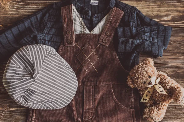 Flat lay fotografía de trajes casuales de niño, Trajes de viajero, niño, hombre, Trajes casuales de los hombres en el fondo del tablero de madera - Imagen de estilo efecto Vintage — Foto de Stock