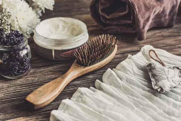 Set de spa natural para mujer. Cuidado del cabello, mimos. Peine de sándalo, crema. plano laico fotografía, vista superior, fondo de madera — Foto de Stock