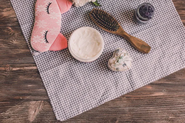 Doğal spa kadın için ayarla. Saç Bakımı, şımartan. Sandal ağacı tarak, krema, uyku maskesi. Düz yatıyordu Fotoğrafçılık, üstten görünüm, ahşap arka plan