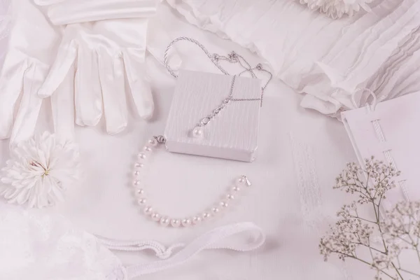 Witte bruids accessoires voor bruiloft achtergrond met parels, witte satijnen linten en kant, handschoenen, armband, platte lay voor mode blog, top view — Stockfoto