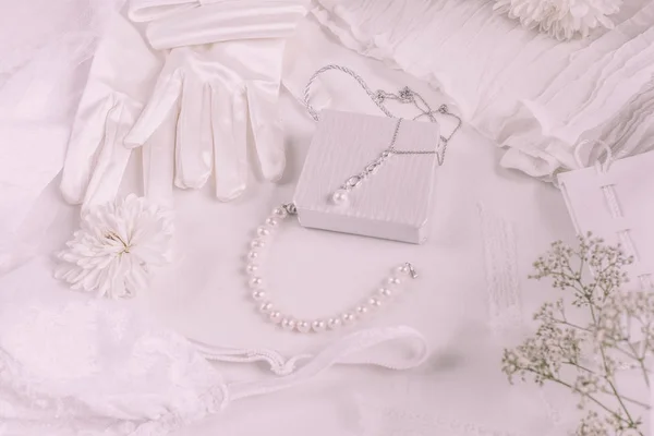 Witte bruids accessoires voor bruiloft achtergrond met parels, witte satijnen linten en kant, handschoenen, armband, platte lay voor mode blog, top view — Stockfoto