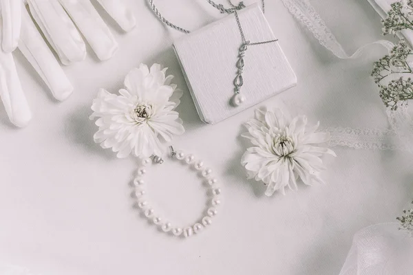 Acessórios de noiva branco para fundo do casamento com pérolas, fitas de cetim branco e rendas, luvas, pulseira, flat lay para blog de moda, vista superior — Fotografia de Stock