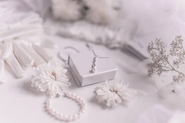 Λευκά νυφικά αξεσουάρ για φόντο γάμου με πέρλες, λευκές σατέν κορδέλες και δαντέλα, γάντια, βραχιόλι, επίπεδο lay για fashion blog, top view — Φωτογραφία Αρχείου