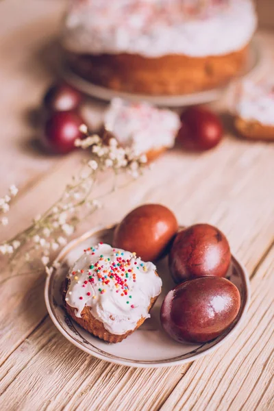 Пасхальный стол с традиционными пасхальными тортами и пасхальными яйцами с цветущей веткой дерева — стоковое фото