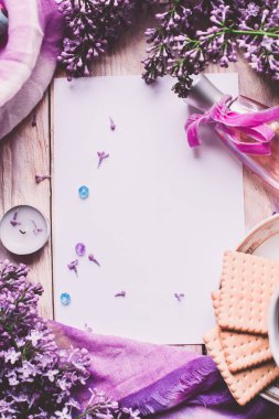 Sabah tişörtü, kurabiyeler ve yukarıdaki ahşap masada leylak çiçeği. Güzel kahvaltı. Kopya alanı ile düz uzanma biçimi