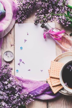 Sabah tişörtü, kurabiyeler ve yukarıdaki ahşap masada leylak çiçeği. Güzel kahvaltı. Kopya alanı ile düz uzanma biçimi