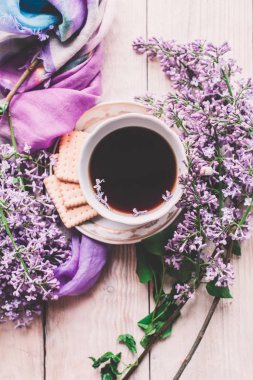Sabah tişörtü, kurabiyeler ve yukarıdaki ahşap masada leylak çiçeği. Güzel kahvaltı. Kopya alanı ile düz uzanma biçimi
