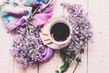 Sabah tişörtü, kurabiyeler ve yukarıdaki ahşap masada leylak çiçeği. Güzel kahvaltı. Kopya alanı ile düz uzanma biçimi