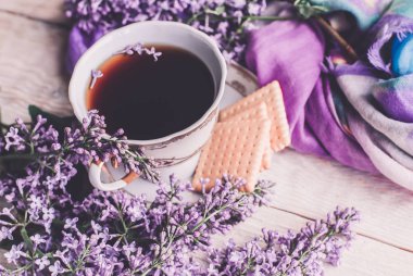 Sabah tişörtü, kurabiyeler ve yukarıdaki ahşap masada leylak çiçeği. Güzel kahvaltı. Kopya alanı ile düz uzanma biçimi