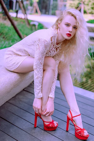 아름 다운 젊은 금발 웃는 행복 한 여자 여름 하루에 분수 근처 흰색 드레스 플레이에 빨간 구두에 빨간 입술으로 — 스톡 사진