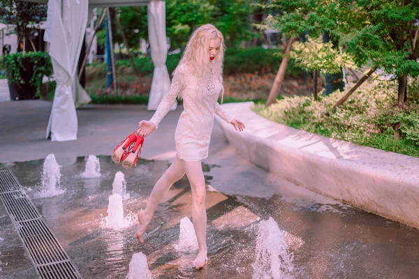 夏の日の噴水の近く白いドレス再生で赤い靴赤い唇と美しい若い金髪笑顔幸せな女 — ストック写真