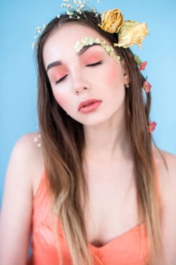 Kozmetik ve manikür. Yakın çekim portre olan kuru çiçekler onun yüz ve saç, pastel renkli, çekici kadın makyaj mükemmel ve mavi arka plan üzerinde deri. Taze, trendy, Bahar düzeltisiz portre