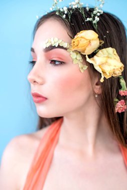 Kozmetik ve manikür. Yakın çekim portre olan kuru çiçekler onun yüz ve saç, pastel renkli, çekici kadın makyaj mükemmel ve mavi arka plan üzerinde deri. Taze, trendy, Bahar düzeltisiz portre