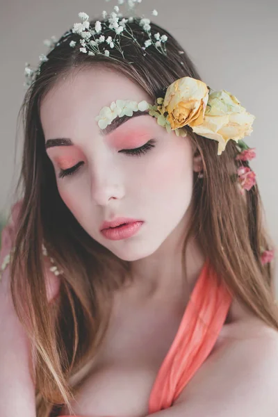 Cosméticos e manicure. Retrato close-up de mulher atraente com flores secas em seu rosto e cabelo, cor pastel, maquiagem perfeita e pele no fundo azul. Retrato retocado de primavera fresco, na moda — Fotografia de Stock