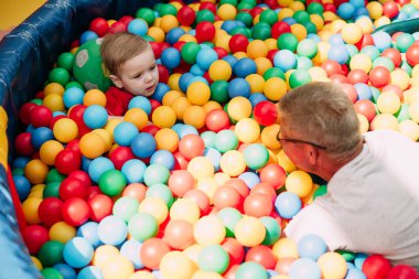 Mutlu gülen çocuk 1-2 yaşında. Büyükbabasıyla eğleniyor. Doğum günü partisinde.. 