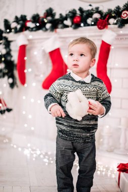 Genç bir çocuğun Noel portresi şöminenin ve Noel ağacının etrafında rahat bir atmosfer.