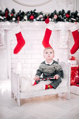 Genç bir çocuğun Noel portresi şöminenin ve Noel ağacının etrafında rahat bir atmosfer.