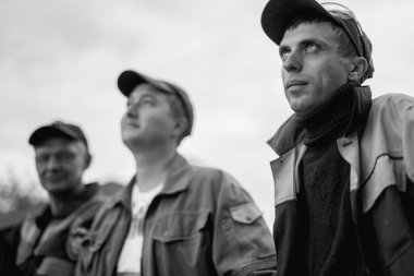 İş, inşaat, takım çalışması ve insanların konsepti - açık havada gülen inşaatçılar grubu