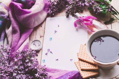 Sabah tişörtü, kurabiyeler ve yukarıdaki ahşap masada leylak çiçeği. Güzel kahvaltı. Kopya alanı ile düz uzanma biçimi