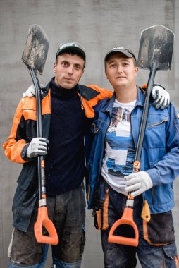 İş, inşaat, takım çalışması ve insanların konsepti - açık havada gülen inşaatçılar grubu