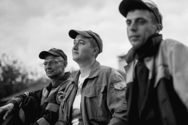 İş, inşaat, takım çalışması ve insanların konsepti - açık havada gülen inşaatçılar grubu