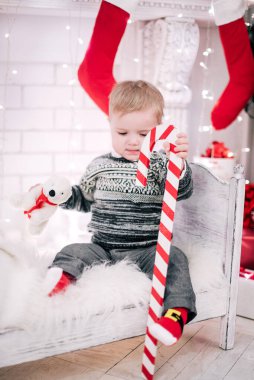 Genç bir çocuğun Noel portresi şöminenin ve Noel ağacının etrafında rahat bir atmosfer.