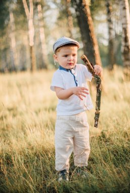 Mutlu küçük bir çocuğun portresi dışarıda eğleniyor, yaz ormanlarını keşfediyor.