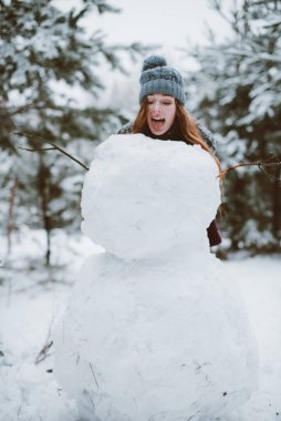 İki genç yeniyetme kız arkadaş bir arada. İki kız kardeşin moda portresini yakın çekin. Kışları eğlenin, süveter giyin, en iyi arkadaşlar açık havada, karlı havada.