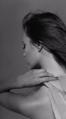 Pembe kurdeleli uzun kıvırcık saçlı güzel, modaya uygun bir kız. Stüdyodaki pembe arka plandaki kız. Moda, güzellik. Parlak kıyafetler. Saç için makyaj malzemeleri, sağlıklı saçlar..