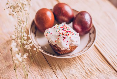 Geleneksel Paskalya pastaları ve çiçek açan ağaç dallı Paskalya yumurtaları olan Paskalya masası, din.