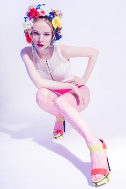 Kafasında çiçekli güzel bir kız pembe külot ve file tayt giyiyor. Mükemmel Cilt. Profesyonel makyaj malzemesi. Moda sanatı. Kırmızı dudaklar.
