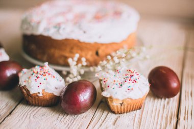 Geleneksel Paskalya pastaları ve çiçek açan ağaç dallı Paskalya yumurtaları olan Paskalya masası, din.