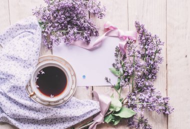 Sabah tişörtü, kurabiyeler ve yukarıdaki ahşap masada leylak çiçeği. Güzel kahvaltı. Kopya alanı ile düz uzanma biçimi