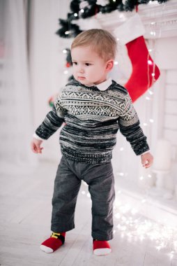 Genç bir çocuğun Noel portresi şöminenin ve Noel ağacının etrafında rahat bir atmosfer.