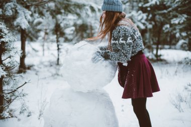 İki genç yeniyetme kız arkadaş bir arada. İki kız kardeşin moda portresini yakın çekin. Kışları eğlenin, süveter giyin, en iyi arkadaşlar açık havada, karlı havada.