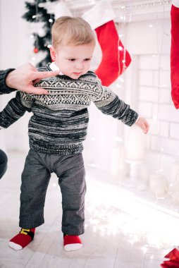 Genç bir çocuğun Noel portresi şöminenin ve Noel ağacının etrafında rahat bir atmosfer.