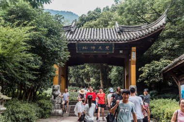 HANGZHOU, ÇİN-Ağustos 04, 2017: Hangzhou, Çin 'deki Lingyin Tapınağı' nda Buda 'ya gülerek turist ziyareti. Mide heykeline dokunmanın şans ve mutluluk getirdiğine inanılır.. 