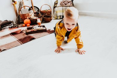 İki yaşındaki havalı hippi çocuk, sonbahar dekorunun süslü fotoğraf sahasında güzel, parlak sonbahar yapraklarıyla poz veriyor. Sıcak atmosfer