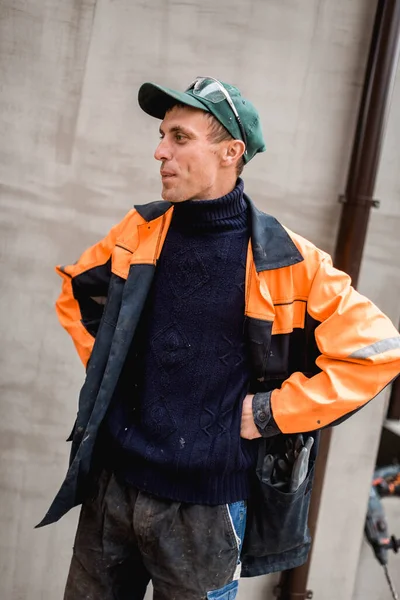 Young construction worker outdoors. Renovation background.