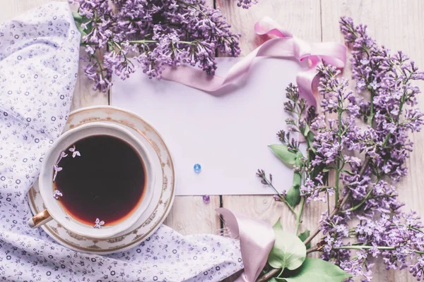 stock image Morning cup of tee, cookies, and lilac flower on wooden table from above. Beautiful breakfast. Flat lay style with copy space