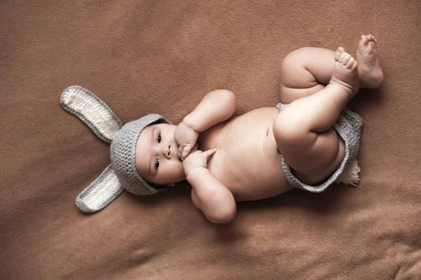 Niño Lindo Mentira Desnuda Sobre Fondo Beige Con Sombrero Ganchillo — Foto de Stock