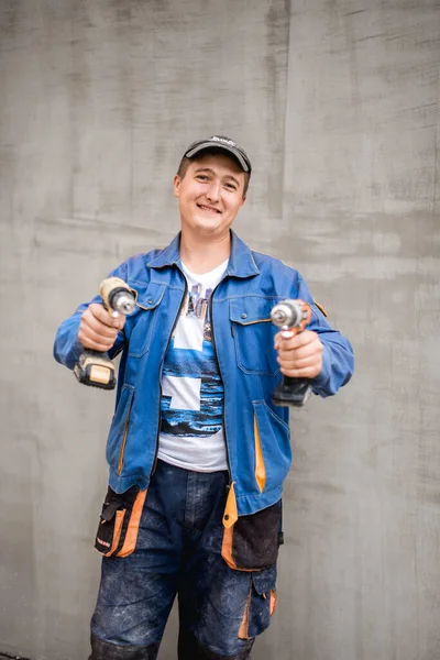 Young construction worker outdoors. Renovation background.