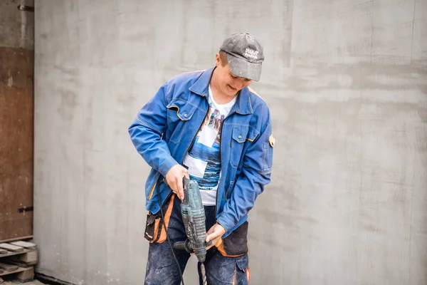 Young construction worker outdoors. Renovation background.