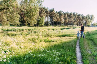 Erkek bebek 1-2 yaşında yazın doğayı keşfediyor, babasıyla eğleniyor. 